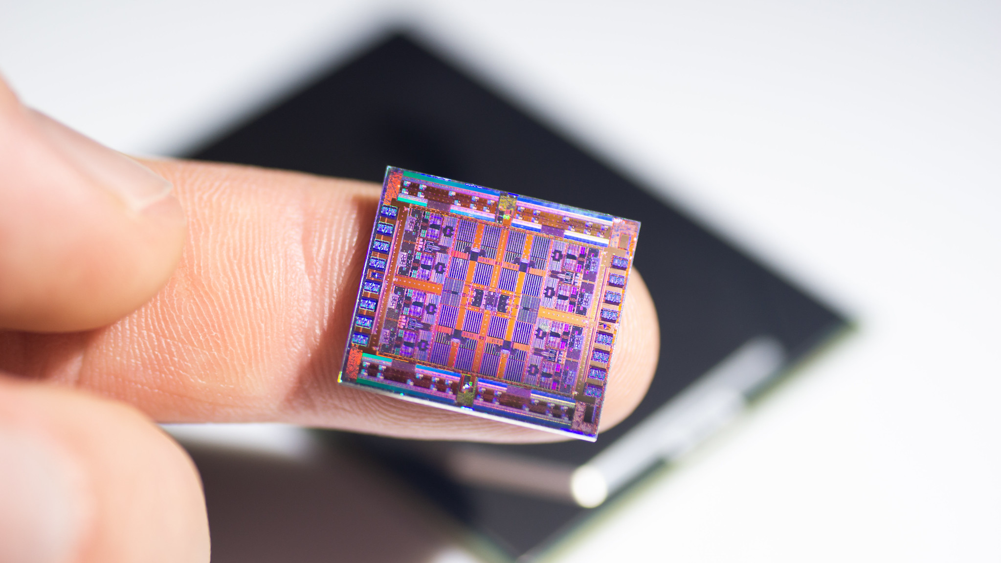 A 28 nm chip sits on the photographer's finger.